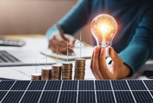 empresaria-segurando-a-lampada-com-turbina-em-moedas-e-painel-solar-contabilidade-de-economia-de-energia-e-financas-de-conceito_34152-1919